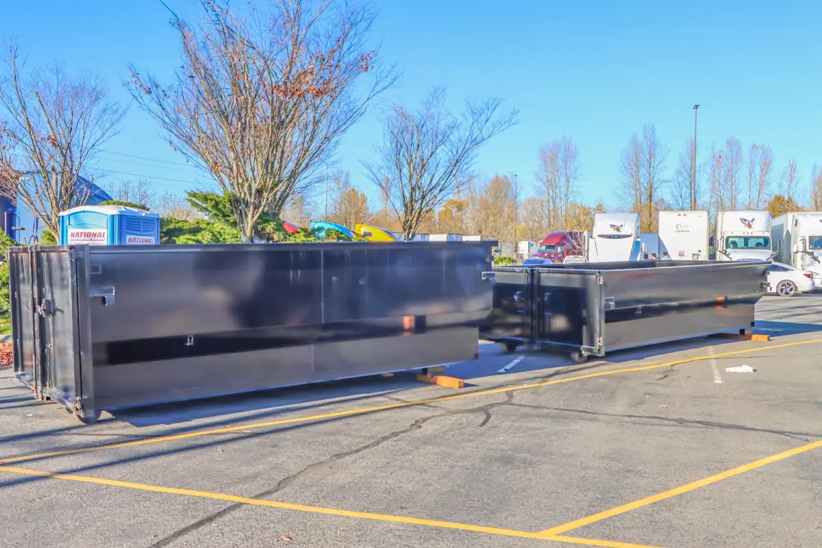 Professional dumpster rental service with roll-off container on residential driveway in Grayling